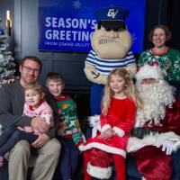 Family with three kids smile with Santa and Louie